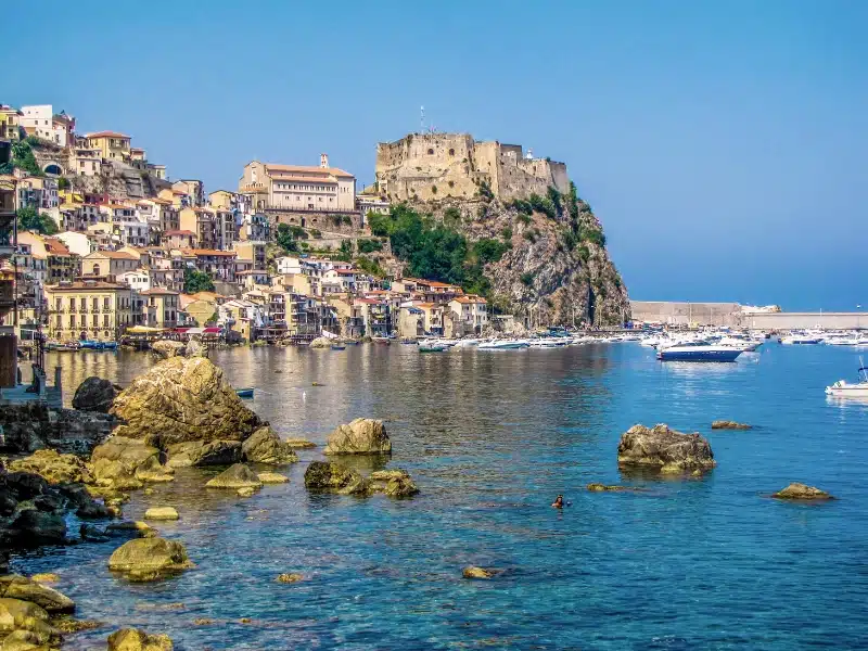 harbour of a trypical Italian fishing village and a castle perched on a rock